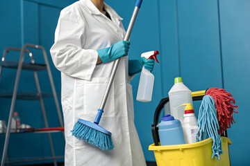 Cleanliness in Detail: A professional cleaning staff member in a crisp white uniform stands ready with a broom and supplies in a close-up image.