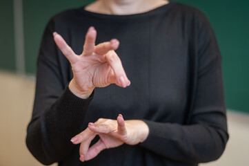 A woman shows the word project in Russian sign language. 