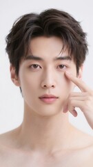 目の下を指差して見せるハンサムな男性