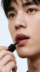 アプリケーターで唇にリップを塗る男性