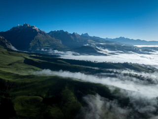Aerial view of beautiful high altitude snow capped mountains and forest grassland landscape in China