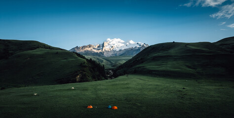 Aerial view of beautiful high altitude snow capped mountains and forest grassland landscape in China