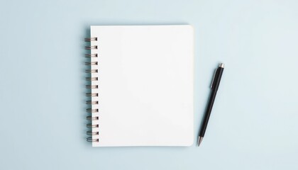 Blank spiral notebook and pen on blue background