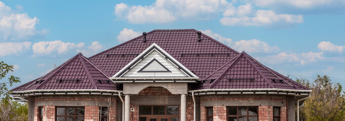 house under construction with metal slate roof against sky