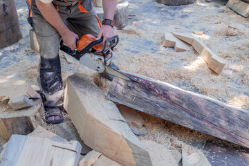 Man is cutting wood with a chainsaw