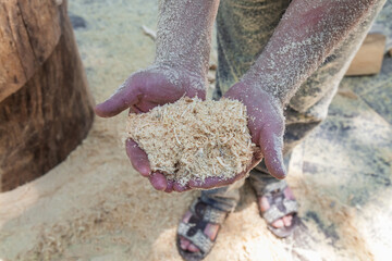 Man is holding a handful of wood chips