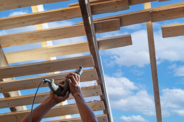 Builders in work clothes install new roofing tools, roofing tools, electric drill and use them on...