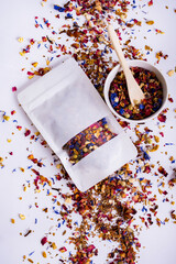 White packaging with herbal tea mockup for logo or inscription. Dry herbal tea blend with leaves...