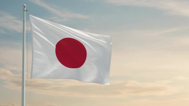 Large national flag of Japan waving gently in breeze beneath morning sky. National flag of Japan gently illuminated, its white field and red circle standing out against pale colors.