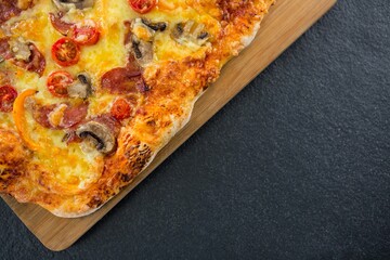 Fresh pizza on wooden plate