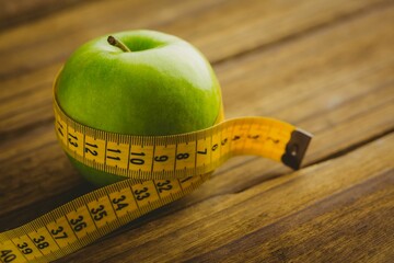 Green apple and measuring tape