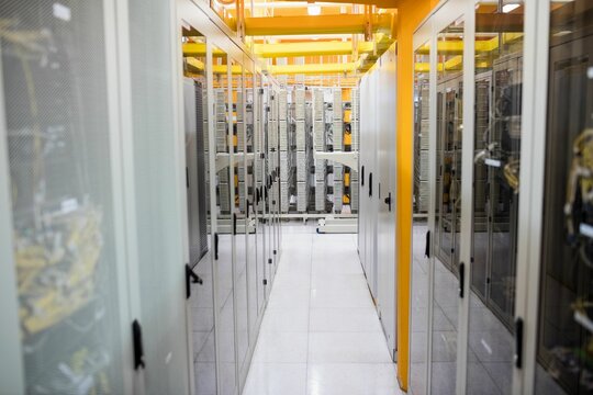 Flat design showing narrow aisle of server cabinets with cables, bright overhead cable trays