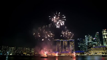 Fireworks over city skyline at night.