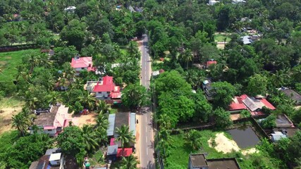 Aerial drone shot of a coastal village near the beach in Alappuzha (Alleppey), Kerala, India — featuring lush green coconut trees, traditional houses, and a serene tropical landscape.