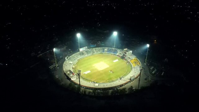 Aerial view of illuminated cricket stadium at night, Pakistan.