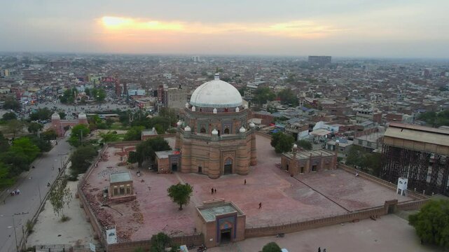 Aerial view of historic temple and cityscape at dusk, Pakistan.