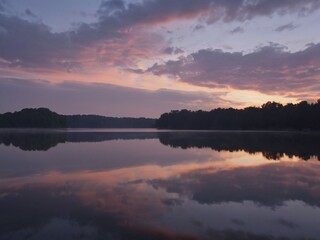 Obraz premium Lake reflecting pink clouds at sunrise