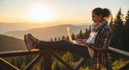Young Woman Sitting on Wooden Fence Using Laptop in Forest Mountain Sunset