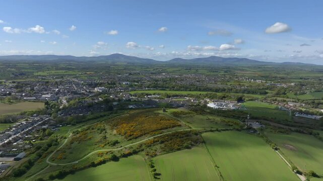 Vinegar Hill, Enniscorthy, County Wexford, Ireland, April 2025. Drone panoramic aerial establishing orbit clockwise and slow descend as cloud shadow texture passes over landscape.