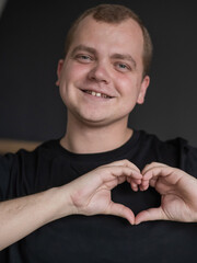 Caucasian man showing heart sign. 