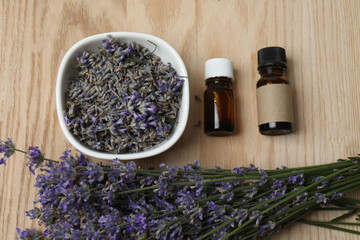 Bottles with lavender oil, lavender on wooden background