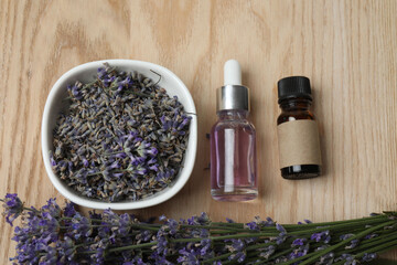 Bottles with lavender oil, lavender on wooden background