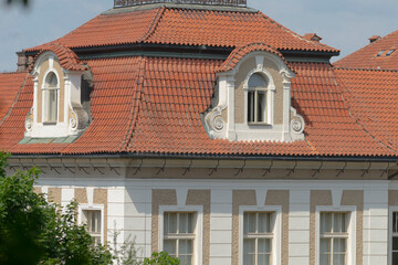 An expansive large white building featuring a striking red tiled roof, which adds to its aesthetic appeal and historical significance