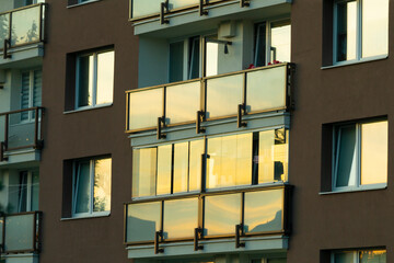 This is a multistory building that features numerous large windows and several balconies throughout...