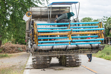 Obraz premium Modern rice harvester on rural road in Thailand