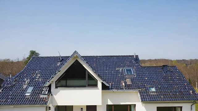 Modern suburban house with dormer window and tile roof on sunny day