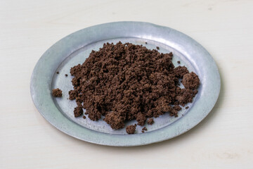 Used black tea granules in a silverware. These versatile tea remnants can be repurposed as natural plant fertilizer, effective deodorizer, or for cleaning surfaces.