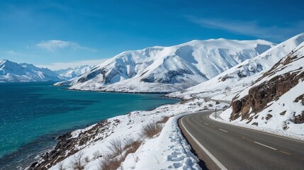A scenic winter landscape with snowcovered mountains and a turquoise lake