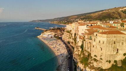 Scenic aerial panorama of Tropea cityscape and coastline with cliffs and clear waters