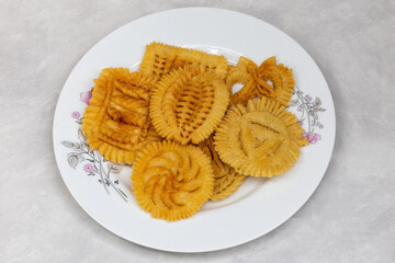 Crispy Nakshi Pitha on a white plate, a traditional Bengali food also known as Pakkon Pitha. This delicious rice flour delicacy is a culinary highlight of Bangladesh.