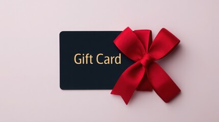 A black card with a red bow on top of it that says "Gift Card"