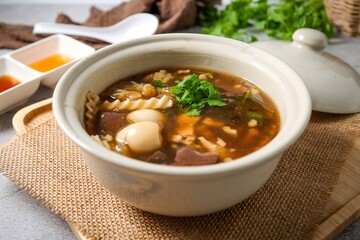 fish maw soup in a white bowl on grey background	