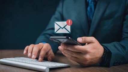 Professional checks email alert on mobile phone with keyboard at desk