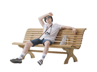 Middle-aged male tourist sitting on a bench, suffering from the heat. Concept of climate change.