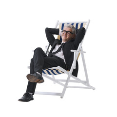 Manager in a black suit relaxing while sitting on a beach chair, isolated on a neutral background.