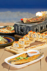 Japanese Fusion Dinner by the Sea, A beautifully arranged seafood dinner featuring sushi rolls,...