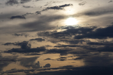 Dramatic sunset with a sky full of dark, stormy clouds. Fading sunlight before dusk, creating an intense and moody atmospheric landscape.