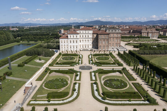 Aerial view of the Palace of Venaria, its manicured gardens a geometric tapestry of green and gold under the vast Italian sky, Venaria Reale, Piedmont, Italy.