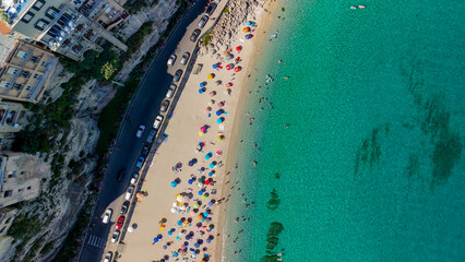Aerial overhead view of Tropea beach with turquoise sea and sun umbrellas in Calabria