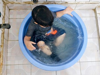 Child Dips in Plastic Tub to Escape Summer Heat