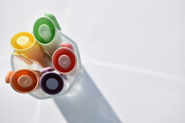 multicolored markers in a glass isolated on a white background, top view