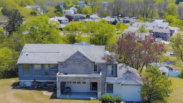 Aerial view of residential house with garage and garden in suburban neighborhood