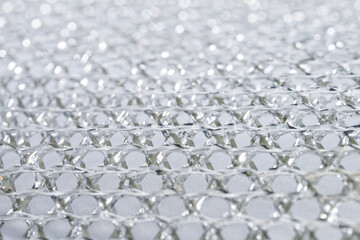 Close-up of intricate mesh pattern of a dishwashing sponge, emphasizing its reflective and high-quality industrial appearance. Photo. High resolution.
