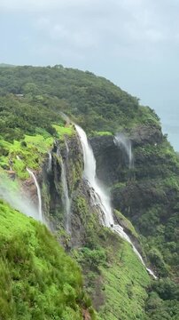 Beautiful landscape of waterfall in the green lush mountains with monsoon season rainy days. Black cloudy rainy weather at Matheran, Maharashtra, India. King george point at Matheran.