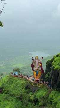 Kadyavarcha Ganpati SG is a temple located at the base point of Peb fort.the statue in between lush green mountains and dark monsoon clouds wiith lake and small houses in background