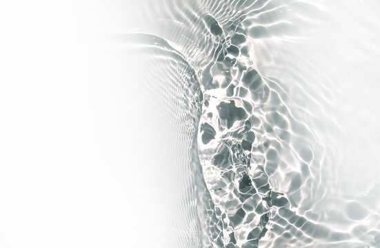 Transparent water waves in sunlight background. Trendy summer nature banner. Defocused aqua-mint liquid colored clear water surface texture with splashes bubbles with copy space.